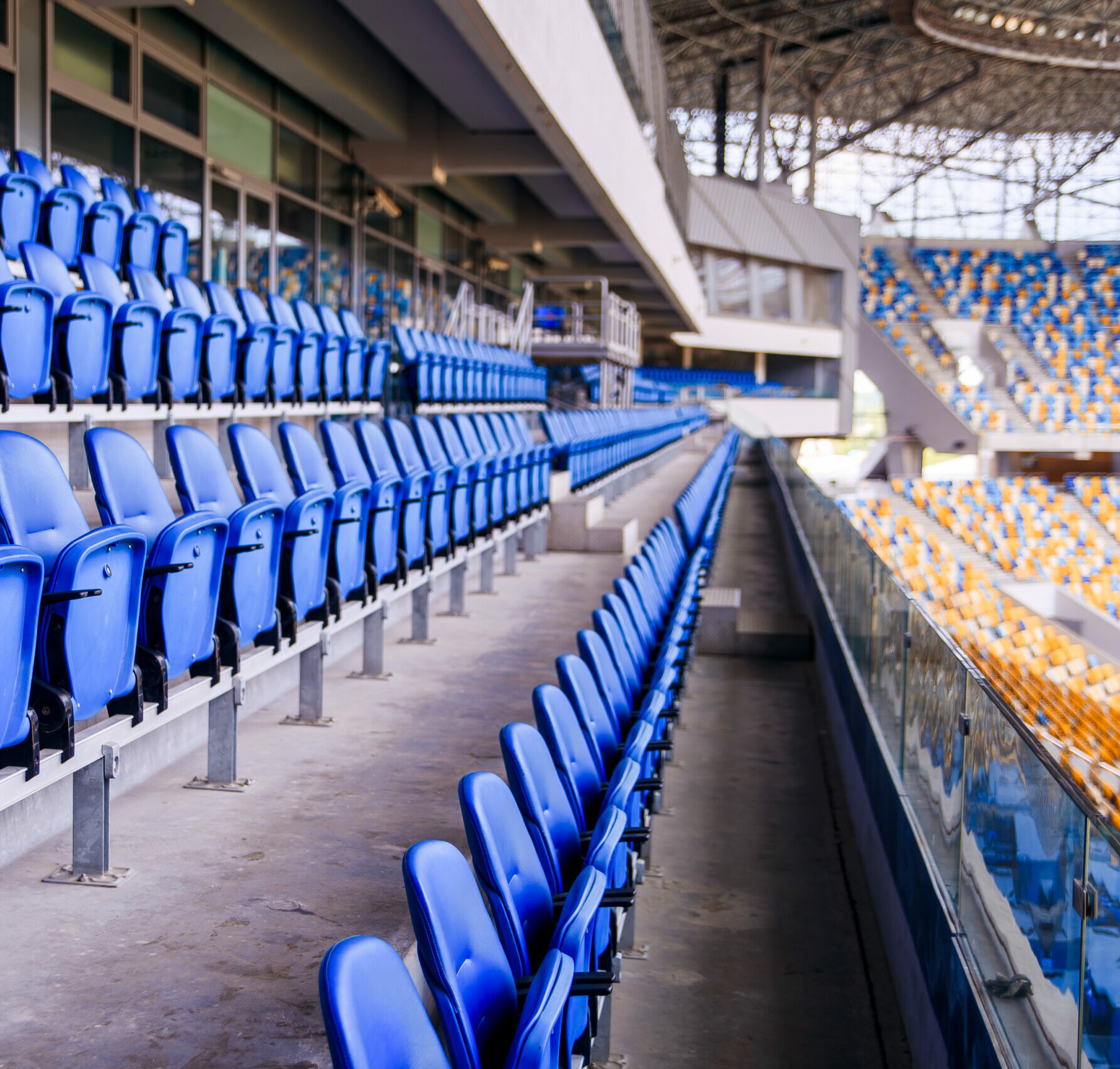 Chaises en plastique bleu vides dans une rangée au stade de football.